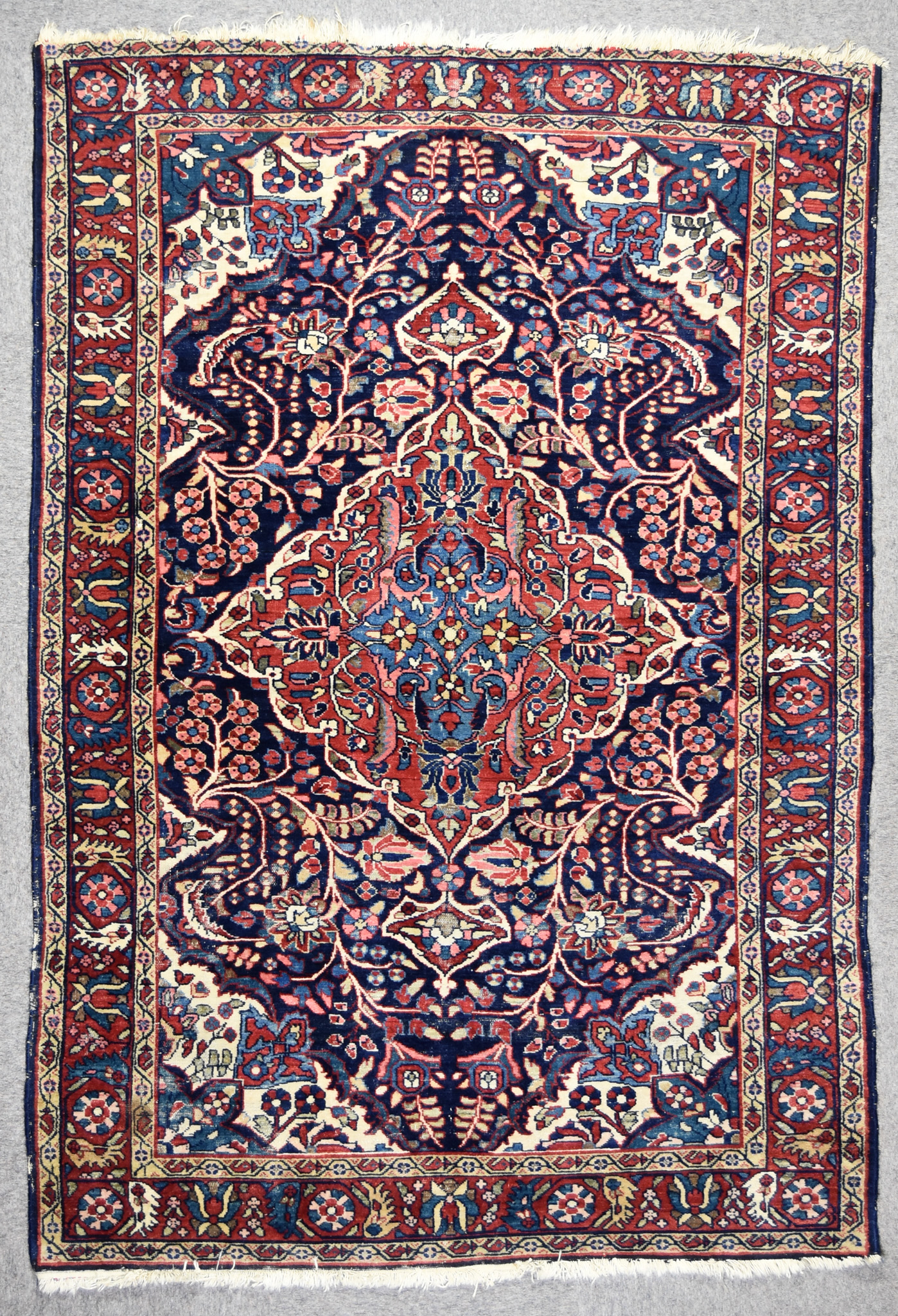 An Antique Borchaloo Rug, woven in colours of ivory, navy blue and wine, with a bold central lozenge