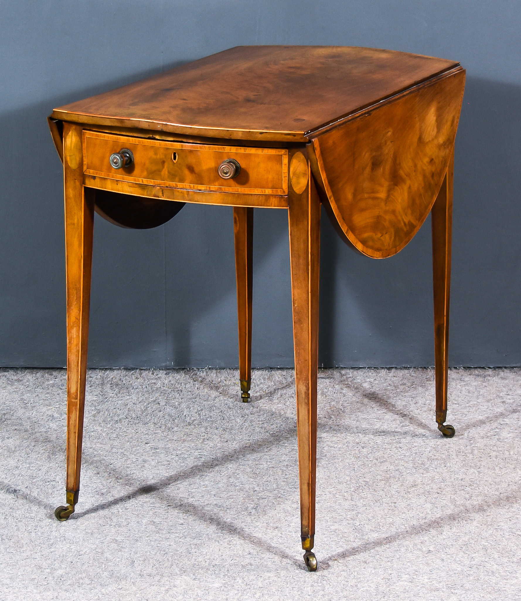 A George III Mahogany Oval Pembroke Table, inlaid with cross bandings to top, fitted one real and
