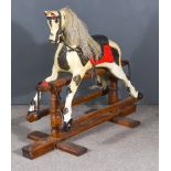 An Early 20th Century Black and White Dappled Rocking Horse, on a turned pine trestle base, 44ins