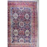 An Antique Bakhtiari Carpet woven in colours, six stylised floral motifs and two urns, on a navy