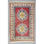 A 20th Century Anatolian Rug of "Kazak" Design, woven in colours, with two hooked lozenge shaped