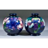 Two Moorcroft Pottery Spherical Vases, tube lined and decorated, one in Anemone pattern on a teal/