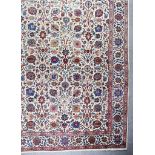 A Fine Antique Tabriz Carpet, woven in colours of ivory, navy blue, wine and fawn, the field