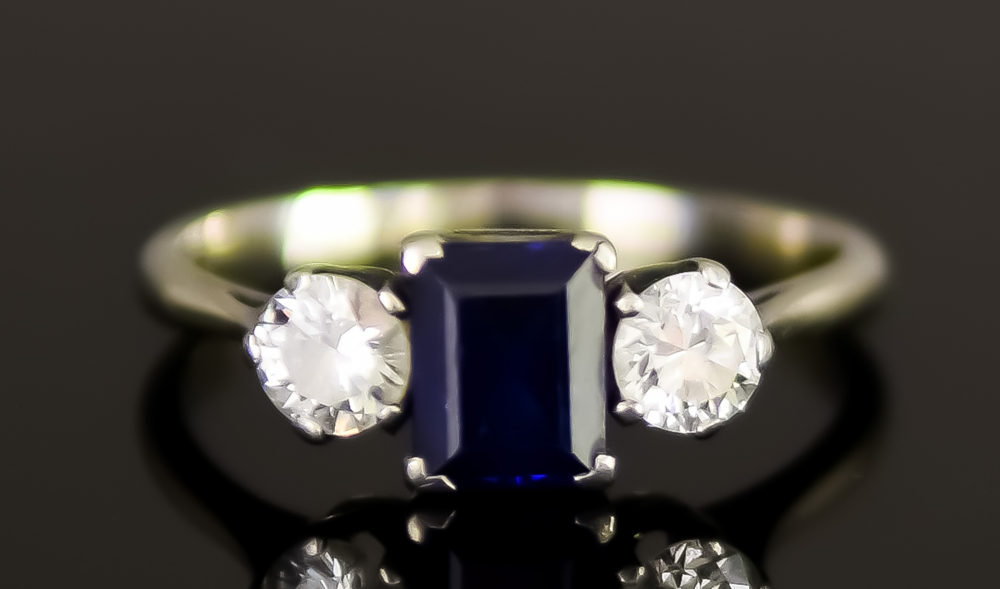 An 18ct White Gold Three Stone Sapphire and Diamond Ring, 20th Century, set with a centre faceted
