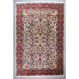 An Antique Tabriz Carpet, woven in colours of ivory, navy blue, green and wine, the field filled