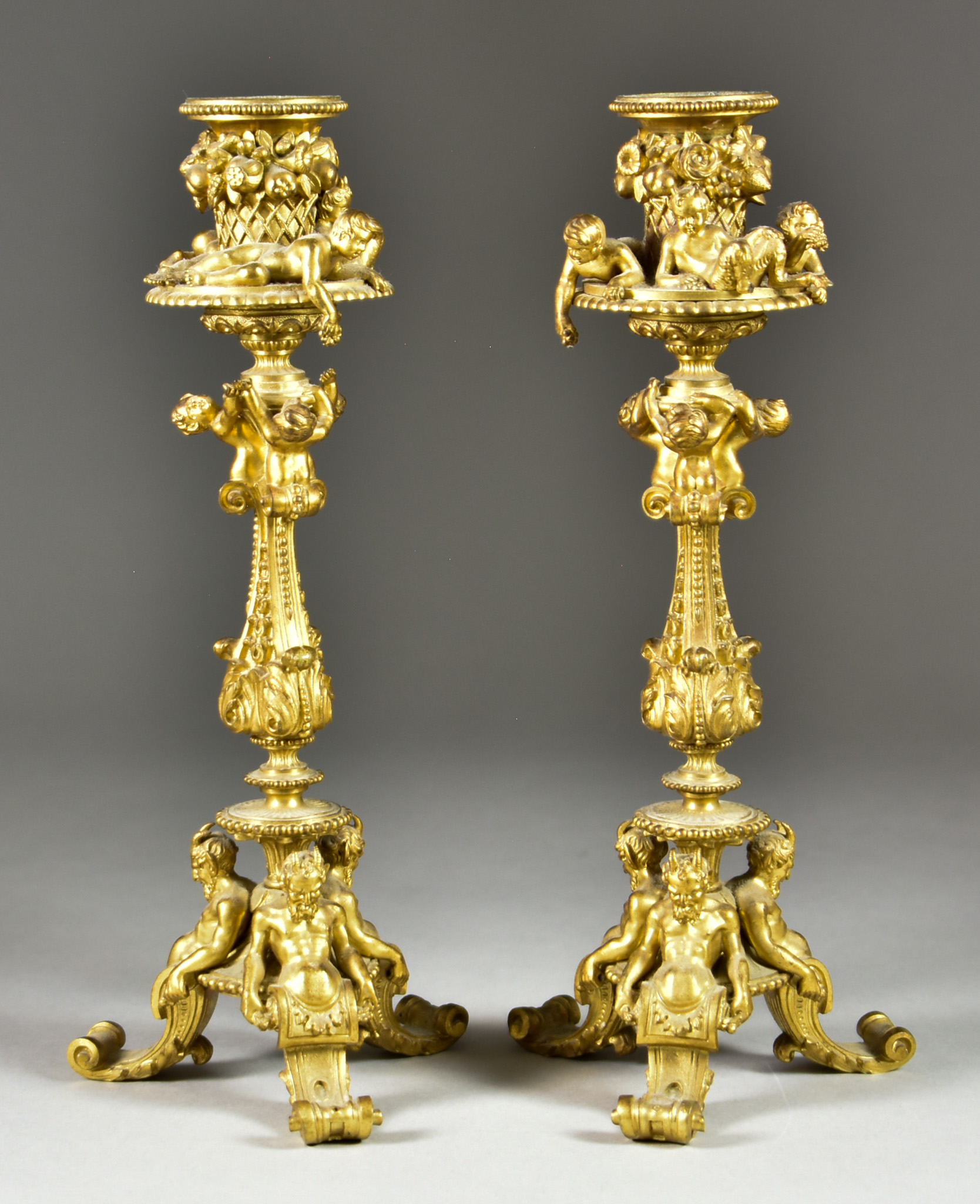 A Pair of Gilt Bronze Candlesticks, Late 19th/Early 20th Century, cast with putto, fawns and