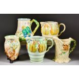 A Selection of Clarice Cliff Relief Moulded Pieces, including jug with green parrot and foliage on a