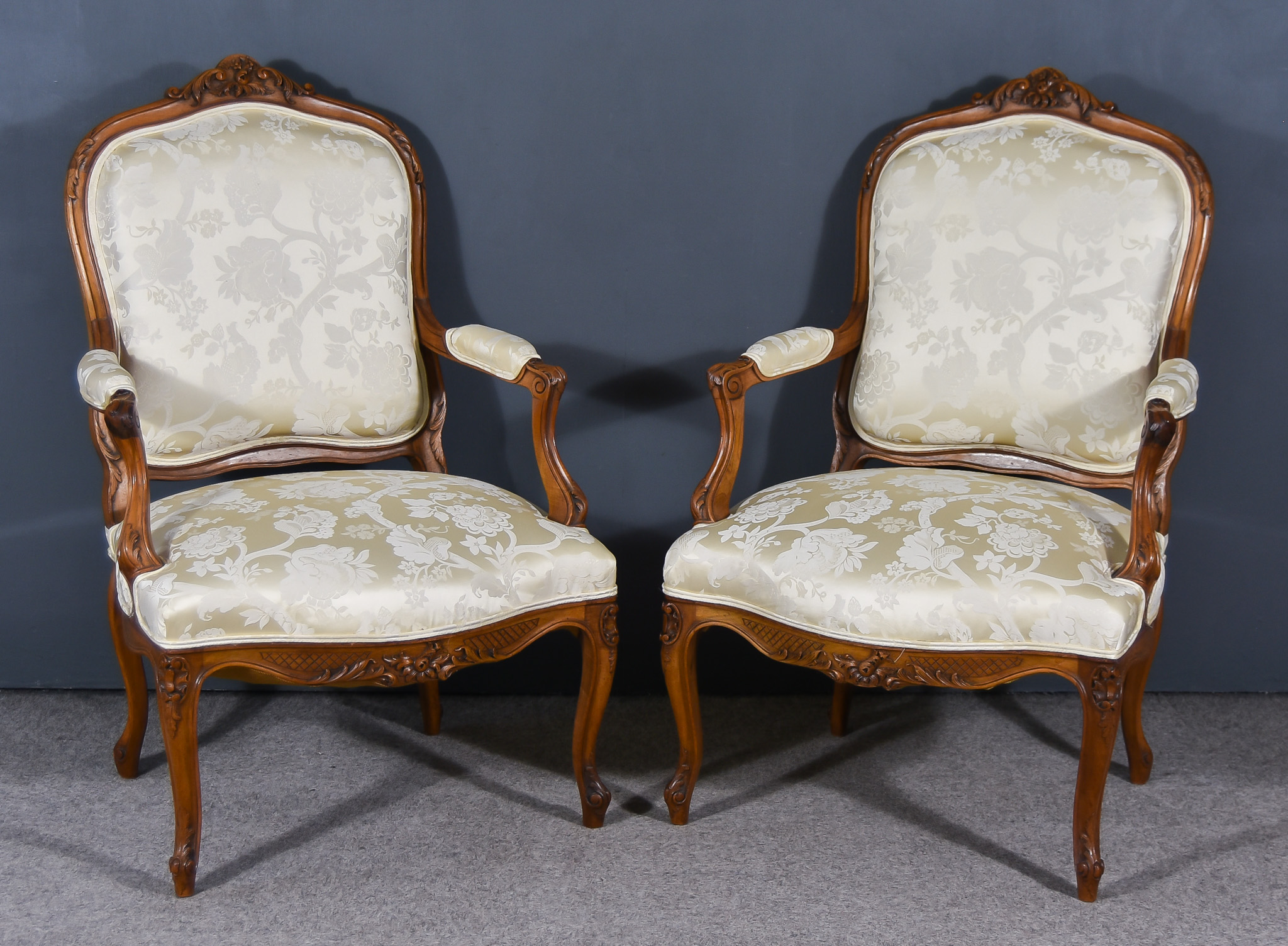 A Pair of 19th Century French Walnut Framed Open Fauteuils of Louis XV Design, with shaped and