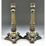 A Pair of Bronzed and Ormolu Brass Candlesticks of Regency Design, with reeded columns over