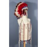 A Lakota Dance Bonnet and Ceremonial Shirt, the bonnet fabricated from painted goose feathers dating