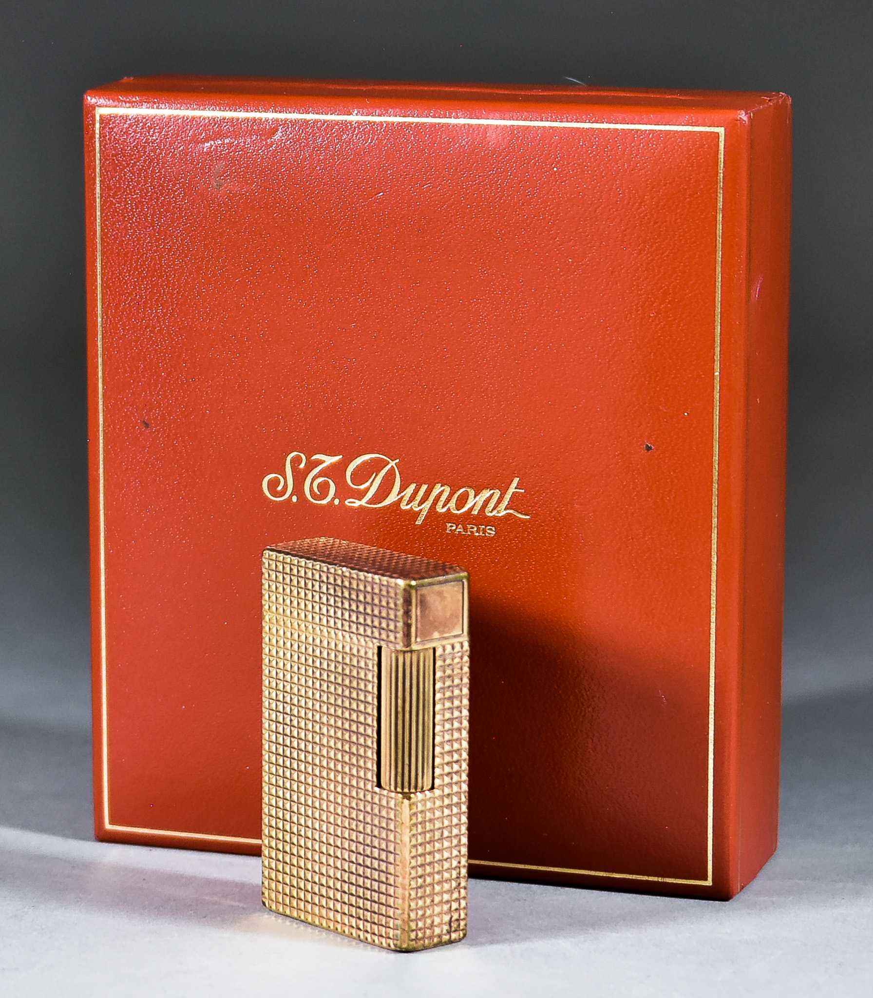 A Dupont Gilt Metal Lighter, with engine turned ornament 2.375ins high, in original case