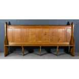 A Large Victorian Oak Pew, with heavy shaped and moulded end supports, panelled back and plain