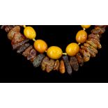 A Quantity of Amber Beads and Rough Amber, comprising - one graduated string of butterscotch amber