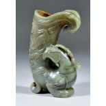 A Chinese Green Hardstone Mythical Bird Vessel, with russet inclusions, the cornucopia-shaped vessel
