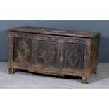 A Late 17th Century Oak Coffer, the three plank top with moulded edge, frieze carved with trefoil