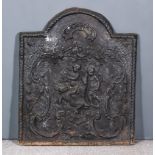 A Cast Iron Fireback of "17th Century" Design, depicting putti with scrolling foliate border,