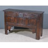 A 16th Century Panelled Oak Coffer, the single plank plain top with moulded front edge, three