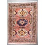 An Antique Kazak Carpet, woven in colours of fawn, navy blue and wine, with three bold hooked star