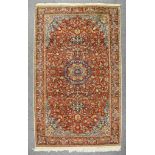 A 20th Century Kashan Rug, woven in colours of terracotta, pastel blue and ivory, with a bold