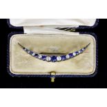A Blue and White Sapphire Crescent Brooch, Early 20th Century, set with blue and white faceted