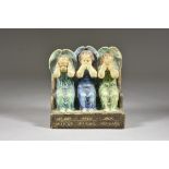 A Compton Pottery Bookend, Early 20th Century, modelled as three angels - "Hear No Evil, Say No