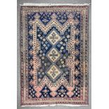 A 20th Century Anatolian Rug of Kazak Design, woven in colours of fawn, navy blue and wine, three