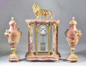 A 19th Century French Rouge Veined Marble and Gilt Brass Mounted Clock Garniture, the four glass