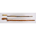 Two Sword Canes, comprising - carved hardwood stick depicting a monkey covering its ears, 27ins