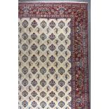 An Antique Isfahan Carpet, woven in colours of ivory, navy blue and wine, the field filled with