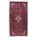An Early 20th Century Afshar Carpet, woven in colours of madder, navy blue, fawn and ivory, with a