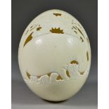 An Ostrich Egg, 20th Century, carved and pierced with a hippopotamus, 6ins high
