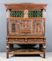 An Oak Cabinet, with moulded cornice, two stained glass panels, three cupboards under enclosed by