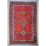 An Early 20th Century Qashqai Rug, woven in colours of ivory, navy blue, wine and green, with