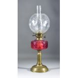 A Victorian Brass Table Oil Lamp, with moulded cranberry glass reservoir on engraved column and
