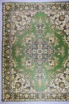 A 20th Century Indian Carpet of Kirman Design, woven in colours of green, ivory and fawn, the bold