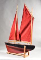 A Black and Red Painted "Lugger", 25ins overall, and a green painted pond yacht, 27ins overall