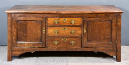 An Old Panelled Oak Dresser Base, with moulded edge to top, fitted three central drawers, flanked by