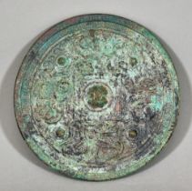 A Chinese Patinated Bronze Circular Mirror with Plain Face of Early Archaic Form, the reverse cast