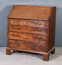 A George III Mahogany Bureau, the slope enclosing eight small drawers and pigeon holes, fitted