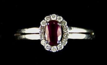 An 18ct White Gold Ruby and Diamond Ring, set with a central ruby, approximately .50ct, surrounded