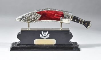 A Presentation Kukri, in highly decorated silvery metal scabbard,15ins overall, on painted wood base