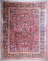 An Antique Sarough Carpet woven in colours of ivory, navy blue, wine and green, the field filled