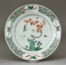 A Chinese Kangxi Famille Verte Plate, enamelled with rock work, prunus blossom and a bird, 6.5ins (