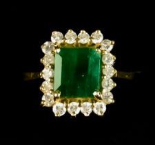 An Emerald and Diamond Ring, set with a centre faceted emerald, approximately 1.5ct, surrounded by