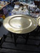 ORIENTAL BRASS TRAY TOP FOLDING TABLE WITH INCISED DECORATION IN THE FORM OF DRAGONS IN PURSUIT OF