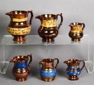 THREE LATE VICTORIAN COPPER LUSTRE EARTHENWARE JUGS, having mustard colour bands painted in gilt