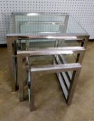A NEST OF THREE BRIGHT STEEL CONTINUOUS FRAMED OBLONG COFFEE TABLES, WITH GLASS TOPS