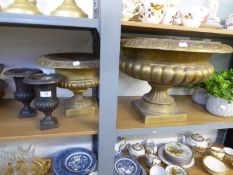 A LARGE GILT COLOURED PEDESTAL URN SHAPED PLANTER, A SIMILAR SMALLER PLANTER, A PAIR OF SMALL CAST