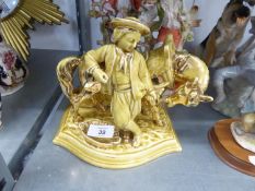 EICHWALD YELLOW AND GILT GLAZED POTTERY GROUP OF A BOY HOLDING HIS HORSE