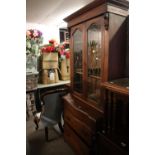 A CONTINENTAL MAHOGANY ELEVATED BOOKCASE, TWO GLAZED DOORS ABOVE THREE DRAWER BASE